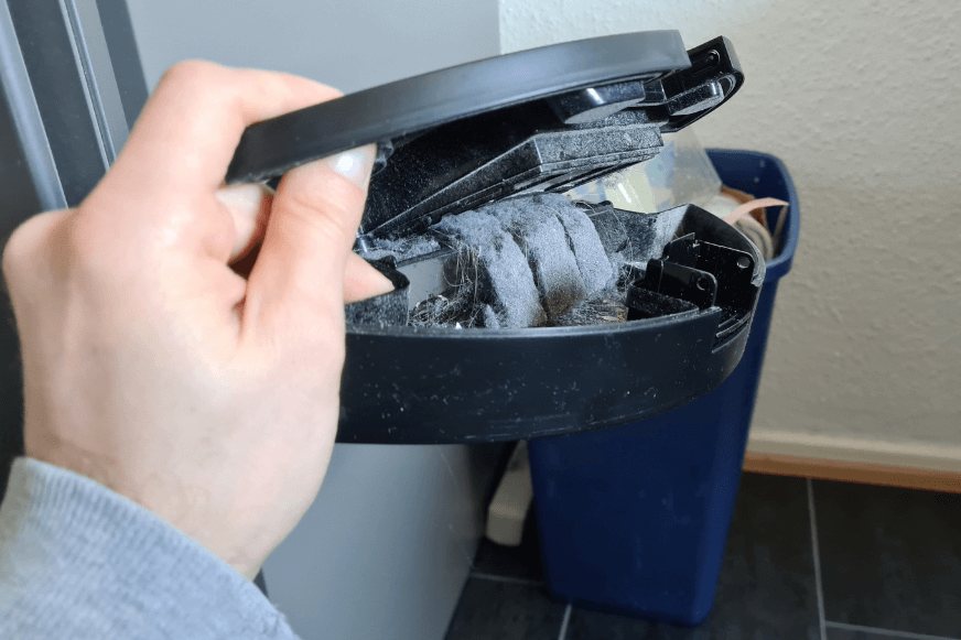 Der mobile Staubbehälter eines Shark Saugroboters wird entleert.